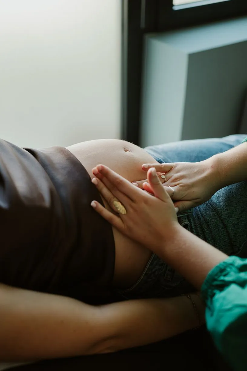 Vroedvrouw voelt aan de buik van een zwangere vrouw