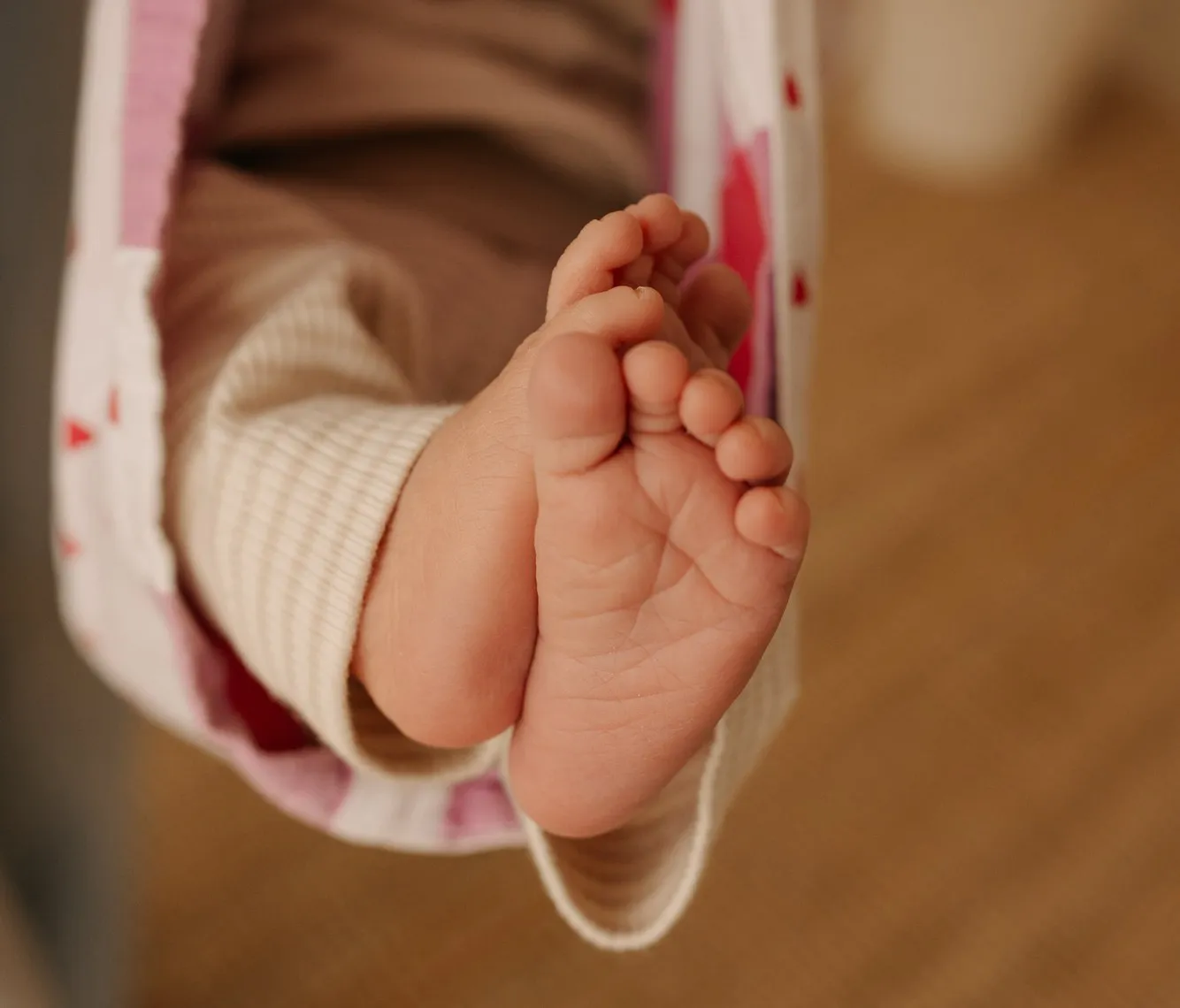 Babyvoetjes die uit een draagdoek steken