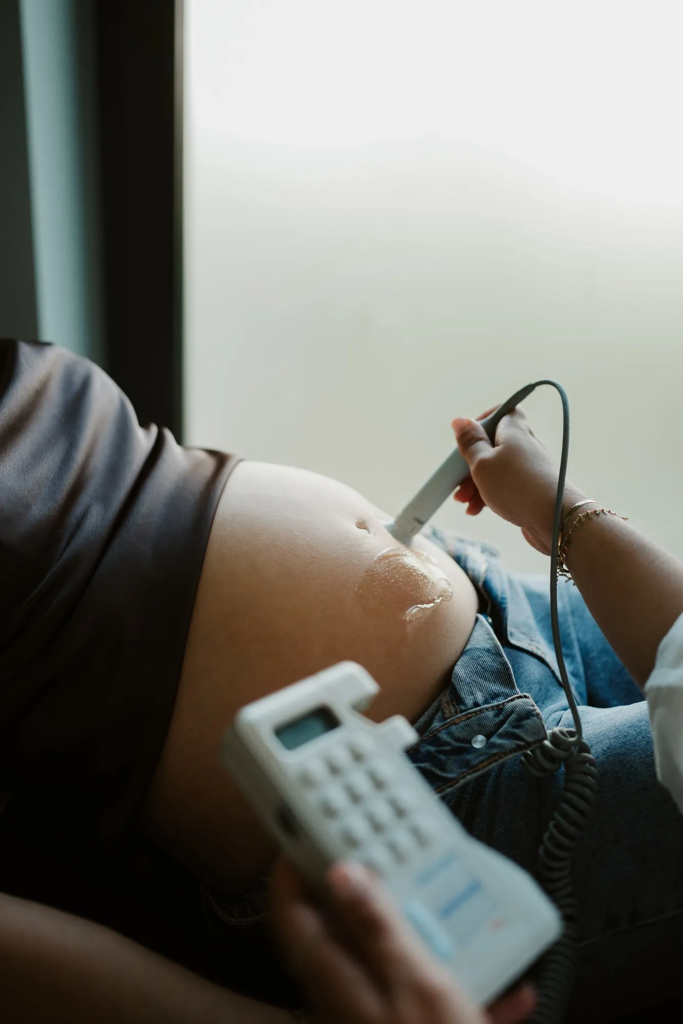 Vroedvrouw luistert met een doptone naar de harttonen van de baby